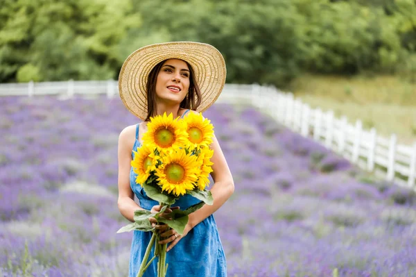 女人抱着一束向日葵在薰衣草田地 — 图库照片