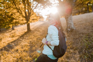 Sırt çantası ile öğleden sonra sonbaharda hafif ormanında 