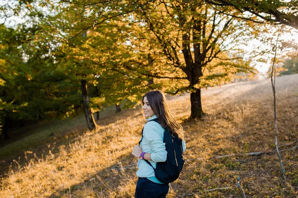 Kobieta na wzgórzu w lesie z plecaka — Zdjęcie stockowe