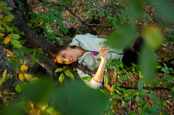 Mulher deitada relaxada em um galho de árvore — Fotografia de Stock