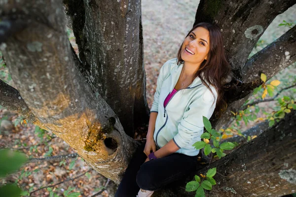 Jonge vrouw in een oude grote boom klom. — Stockfoto