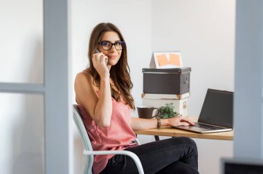 Ofiste durmuş telefonda konuşan bir kadın.