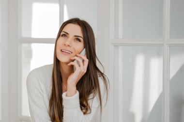 Kadın cep telefonuyla konuşuyor.