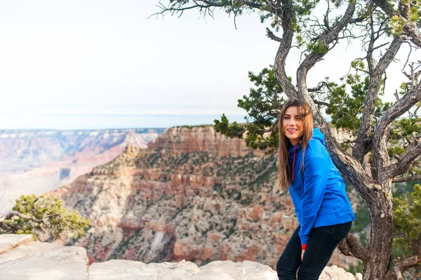 Travel hiking photo of young beautiful woman at Grand Canyon viewpoint, Arizona, USAm smiling at camera. Healthy active lifestyle.