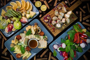 Arka planda domates, ceviz ve tarçınla süslenmiş abur cuburlar: meyve, sebze, patlıcan, peynir