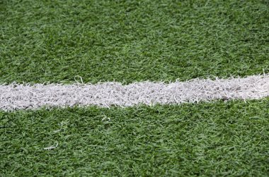 Beyaz çizgi yeşil çimlerin üzerinde koşu şeridi gibi