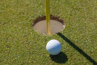 Golf ball on lip of cup