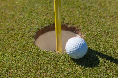 Golf ball on lip of cup