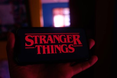 Netflix logosu olan iPhone ve Yabancı Şeyler logosu bir gerilim ve bilim kurgu dizisidir. 17 Şubat 2020, New York, ABD.