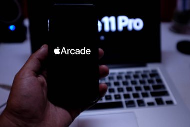 Hava podları, Macbook pro ve iphone 11, Apple Arcade logosuna sahip. Apple Arcade bir video oyunu abonelik servisidir. ABD, New York, Perşembe, 3 Ekim 2020