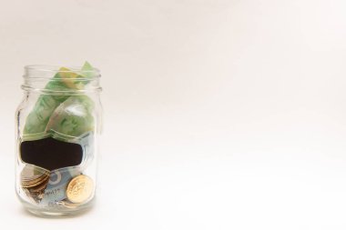 İçinde para olan şeffaf cam bir kavanoz.. 