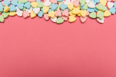 Pembe yüzeyde renkli kalp şeklinde şekerler, Sevgililer Günü