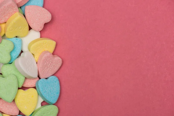 Doces coloridos em forma de coração no topo da superfície rosa, Valentim — Fotografia de Stock