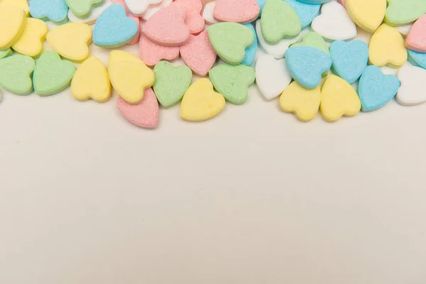 Colorful heart shaped candy on top of white surface , valentine' — ストック写真