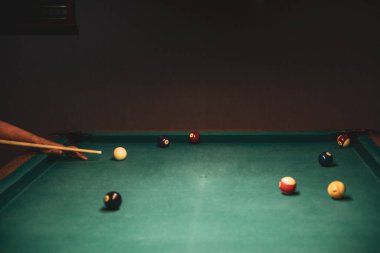 Erkek bilardo topu köşedeki deliğe sokmak için sıraya girer.