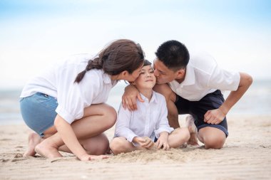 Mutlu Asyalı Aile Baba ve Anne Oğula Sarılma ve Öpüşme, Sahilde Birlikte Tatilin Tadını Çıkartın