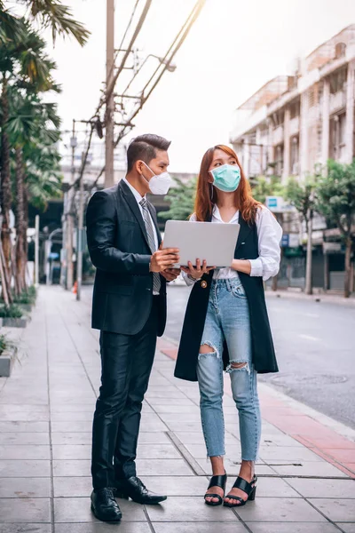 Asian Business People Working and Surveying Outdoor Location for New Business ,They \'re Wearing Protective Mask to Provent Flu and Corona Virus (Covid-19) Outbreak - Healthcare and Business Concept