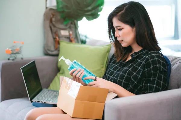 Asian young woman shopping online alcohol gel sanitizer from merchant online store. Stay home and relax on coronavirus outbreak situation concept