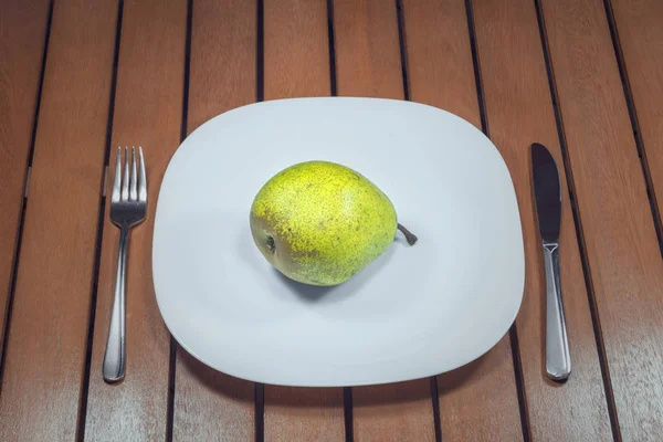 Peer Een Witte Plaat Vork Mes Houten Tafel — Stockfoto