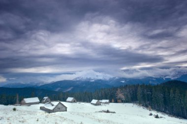 Karda yol olan kış manzarası. Dağ vadisinde bir kulübe. Karpatlar, Ukrayna, Kukul Vadisi