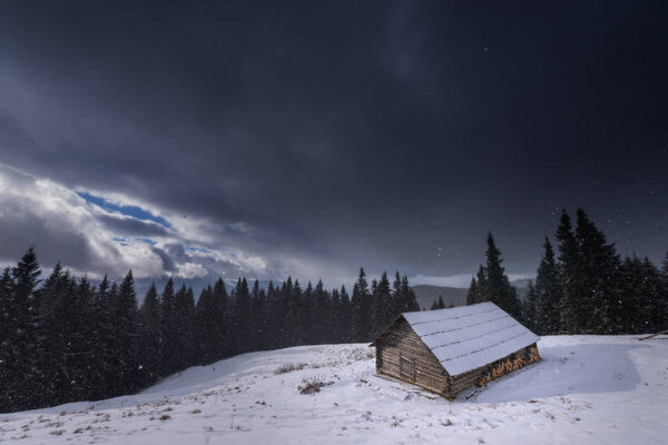Wooden house in the mountains. Christmas scenery and fresh snow. Cloudy day. Carpathian mountains, Ukraine, Europe