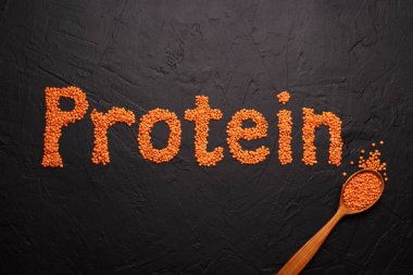 Gri taş zemin üzerinde protein metni olan kırmızı mercimekler