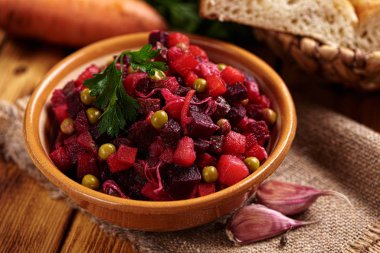 Masada ekmek ve sebzeyle servis edilen pancar salatası.