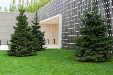 Çevresinde yeşil ağaçlar olan modern bir bina.