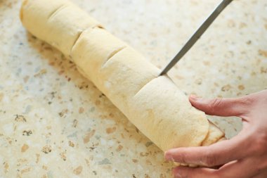 Tarçınlı çörek pişiren kadına yakından bakın.