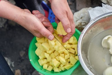 Patatesleri kaseye koyan kişi.