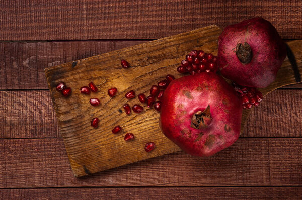 Гранаты с семенами на деревянном столе, деревенский фон
.
