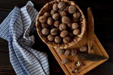 Hasır kasede cevizler tahta tahtada çekiçle