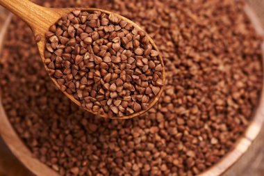 Tahta kase dolusu karabuğday ve kaşık.