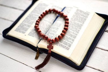 Beyaz ahşap bir masada incili aç.
