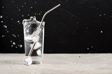 Buz küpleri kara zeminde su bardağına sıçrıyor. Sıfır atık.