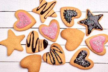 Ev yapımı kurabiye, pembe kremalı kıvırcık kurabiye ve çikolata. Beyaz arkaplanda dekoratif kurabiyeler.