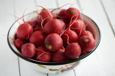 Beyaz arka planda bir kasede taze turp.