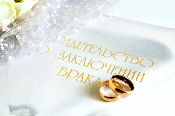 The certificate of registration of marriage and wedding rings on