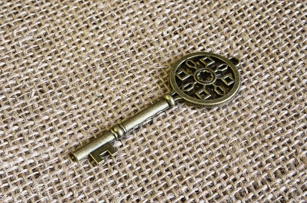 Ancient bronze key on burlap.