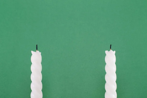 Deux Bougies Blanches Tordues Éteintes Sur Fond Vert Abstraction Inhabituelle — Photo