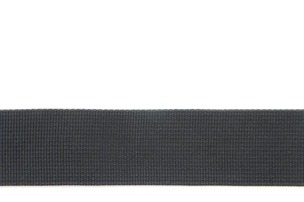 Wide black textile belt. Nothing extra. Belt made of fabric on a white isolated background. The abstraction is interesting. The horizontal location.