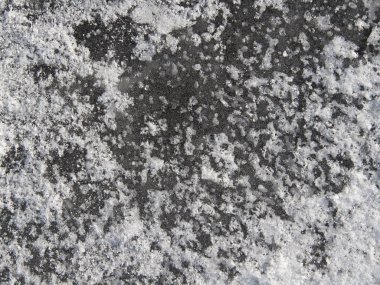 Background of dark ice with frozen snow and snowflakes. Texture.