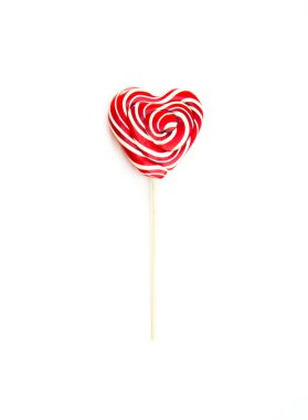 Tahta bir çubukta kalp şeklinde iki tatlı lolipop. Biri kıvrımlı, biri beyaz yalıtılmış arka planda, birbiri üzerine yatay olarak sıralanmış. Şeker içinde aşk ve duygular.