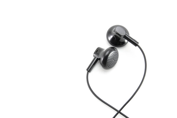 Two small black audio earphones with wire. A mobile headset that plugs into your ear to listen to music. Abstraction on a high quality white isolated background.