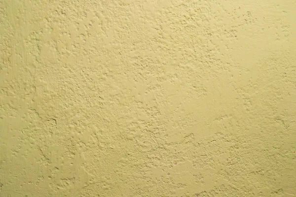 Dark yellow old stucco painted with paint. Uneven and not uniform vintage putty texture. Background.