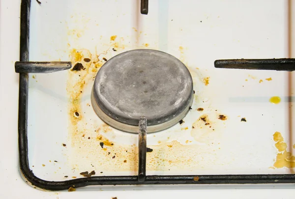 Awful, dirty, not washed gas stove. Close up of white stained comfort stove in the kitchen