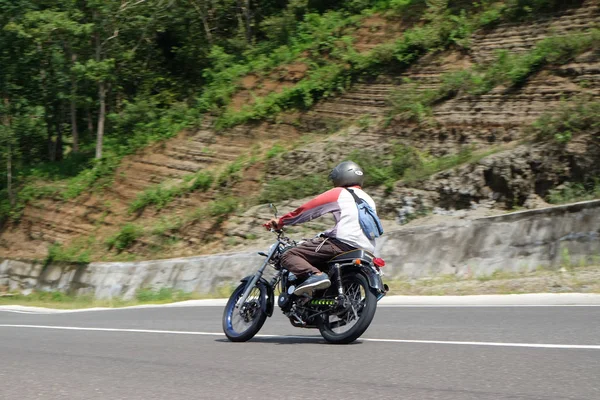 Hombre montando una motocicleta clásica en la carretera de la montaña —  Fotos de Stock