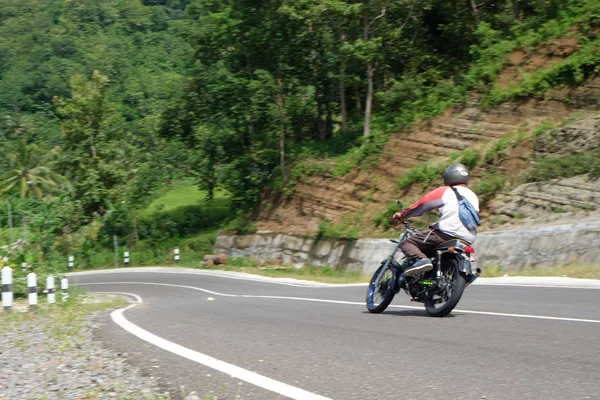 Muž na klasické motorce na horské dálnici — Stock fotografie