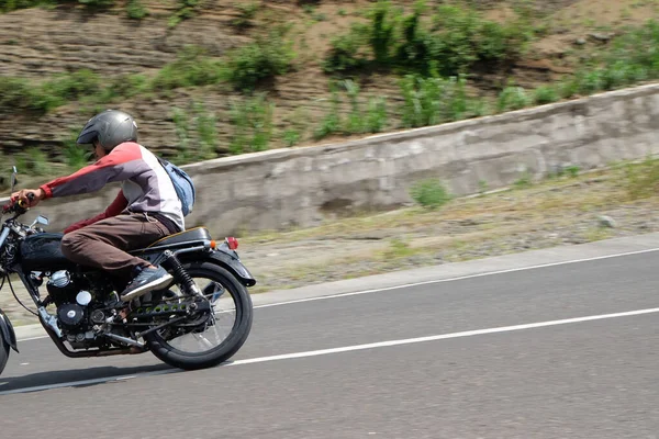 Człowiek jazda klasyczny motocykl na autostradzie górskiej — Zdjęcie stockowe