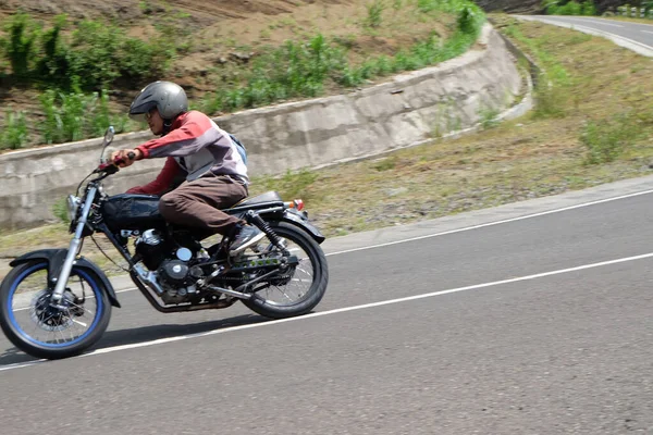 Hombre montando una motocicleta clásica en la carretera de la montaña — Foto de Stock